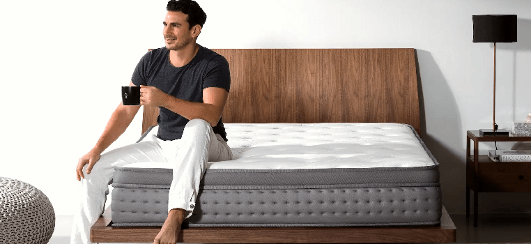 man sitting on noa mattress